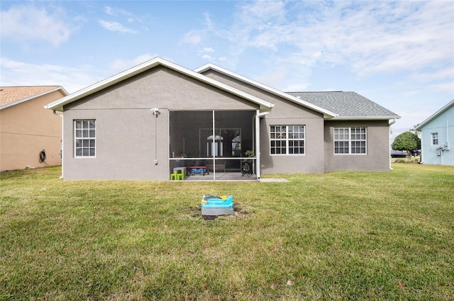 rear view of property featuring a yard and a sunroom