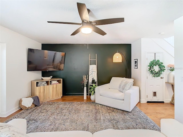 living room with wood-type flooring and ceiling fan