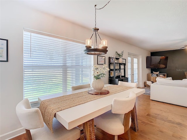 dining space with french doors and light hardwood / wood-style flooring