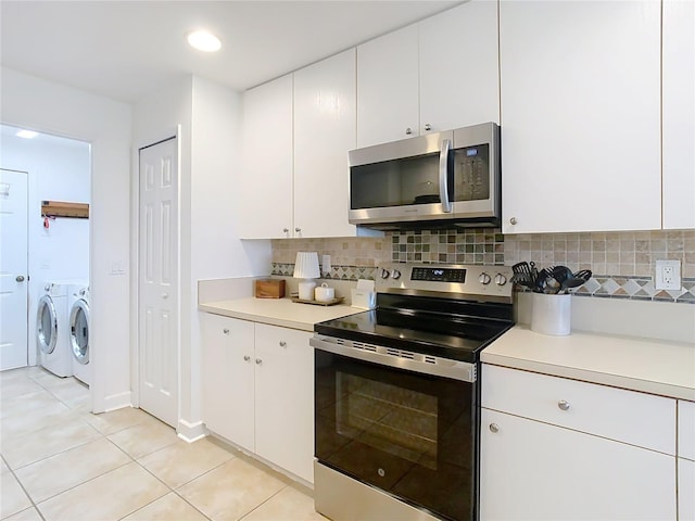 kitchen featuring backsplash, appliances with stainless steel finishes, washer and clothes dryer, and white cabinets