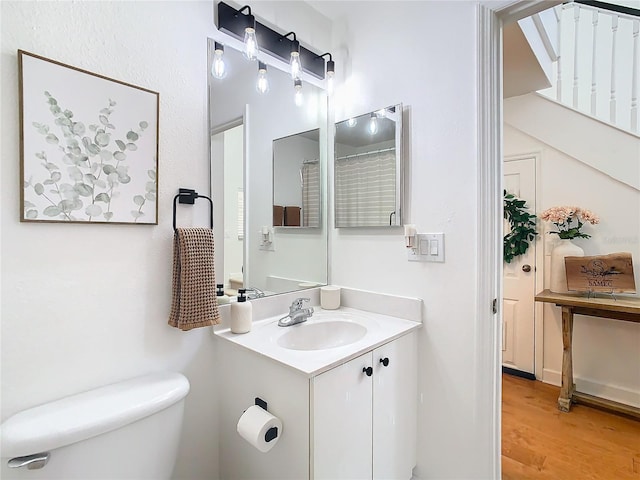 bathroom featuring vanity, toilet, and wood-type flooring