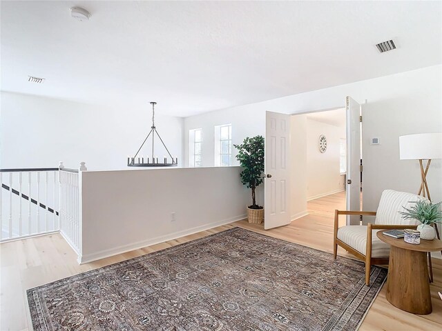 living area featuring a notable chandelier and light hardwood / wood-style flooring