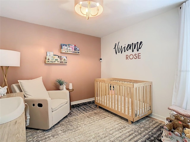 bedroom with a nursery area and a chandelier