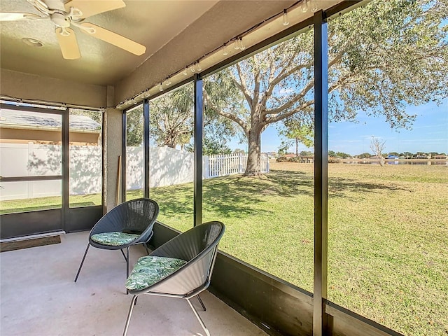 unfurnished sunroom with ceiling fan