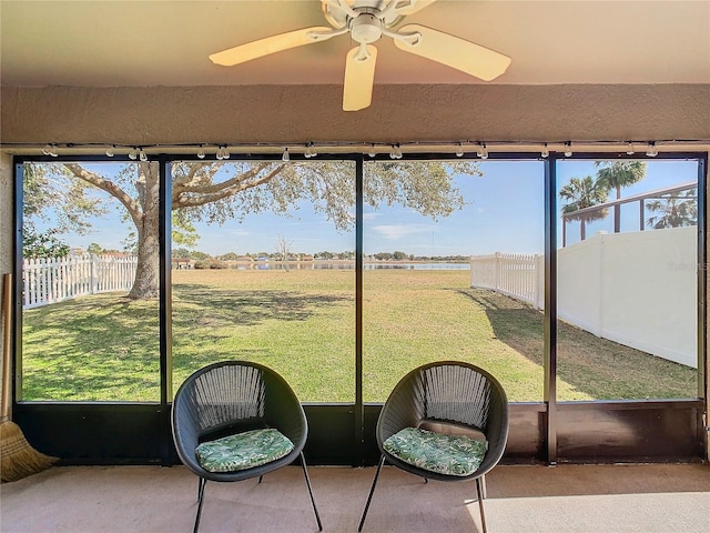 unfurnished sunroom with ceiling fan