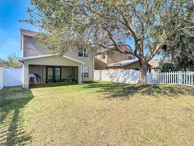 rear view of property featuring a lawn