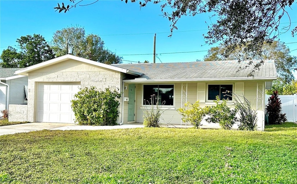 single story home featuring a garage and a front lawn