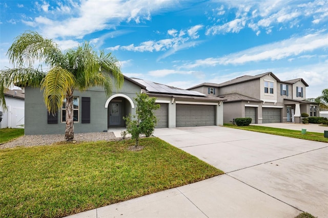 view of front of home with a front yard and solar panels