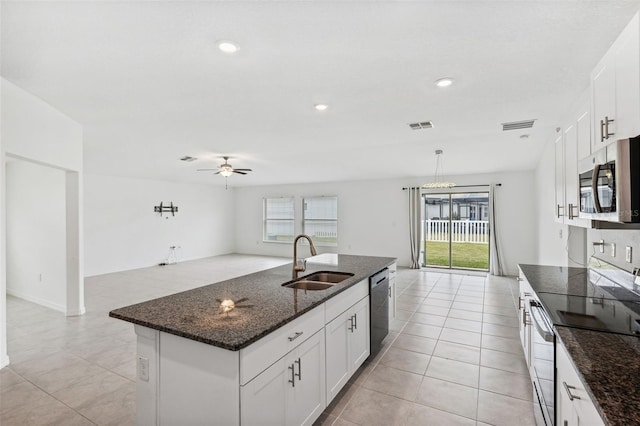 kitchen featuring sink, white cabinetry, stainless steel appliances, and an island with sink