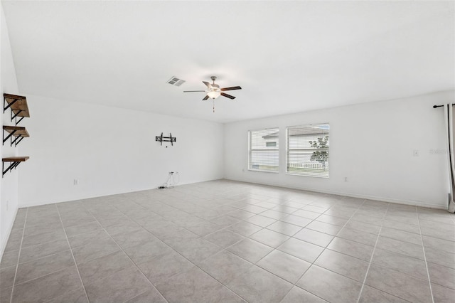 spare room with ceiling fan and light tile patterned floors