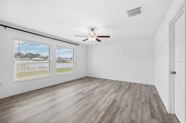 spare room with ceiling fan and light wood-type flooring