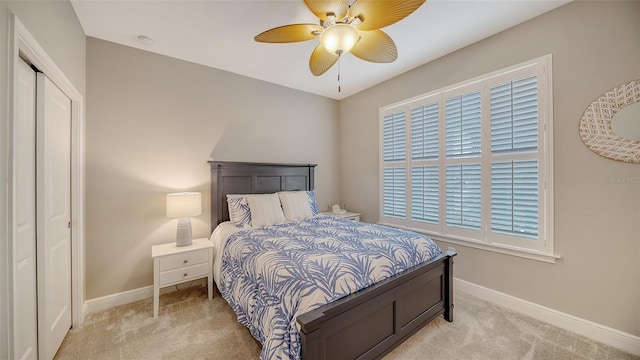 carpeted bedroom with ceiling fan and a closet