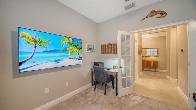 carpeted home office featuring lofted ceiling and french doors