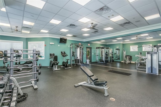 workout area featuring ceiling fan, a drop ceiling, and ornamental molding