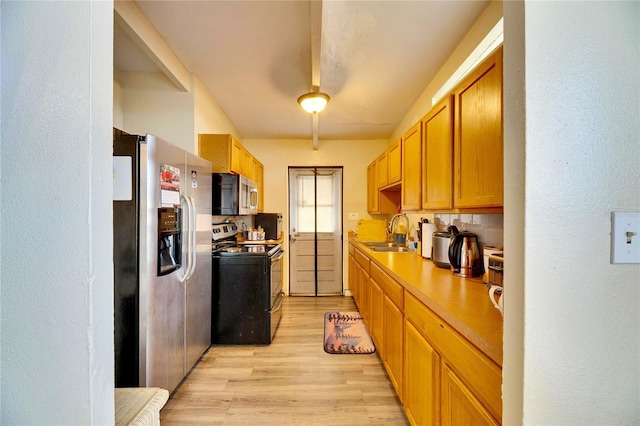 kitchen featuring light wood-type flooring, appliances with stainless steel finishes, and sink