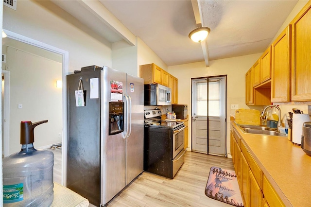 kitchen featuring light wood-type flooring, sink, and stainless steel appliances