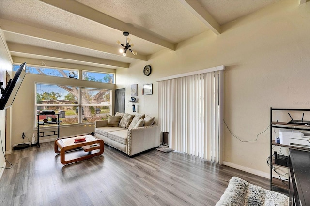 living room featuring a notable chandelier, beamed ceiling, a textured ceiling, and hardwood / wood-style flooring