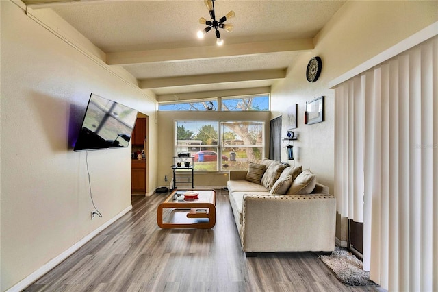 living room with a textured ceiling, hardwood / wood-style floors, and beamed ceiling