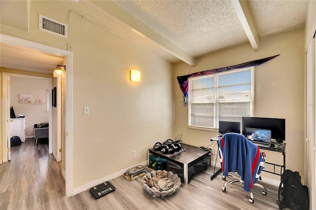 office area featuring a textured ceiling, beam ceiling, and hardwood / wood-style floors