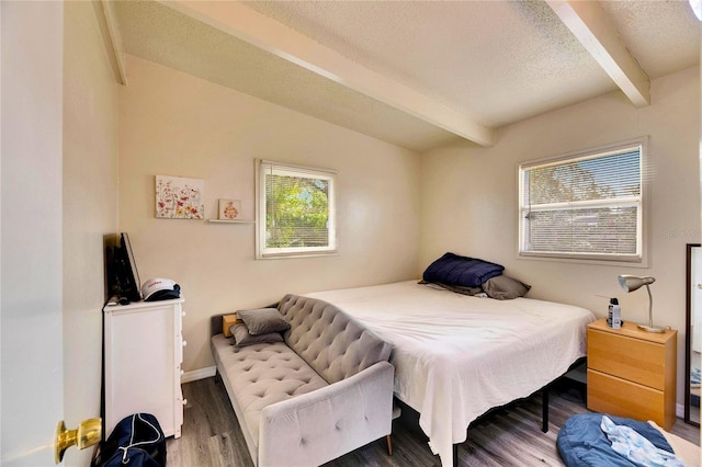 bedroom featuring dark wood-type flooring, a textured ceiling, and beamed ceiling