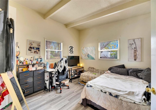 bedroom with light hardwood / wood-style floors and beamed ceiling