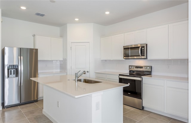 kitchen featuring appliances with stainless steel finishes, white cabinets, a sink, and light tile patterned floors