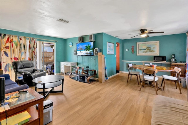 living room with ceiling fan and light hardwood / wood-style flooring