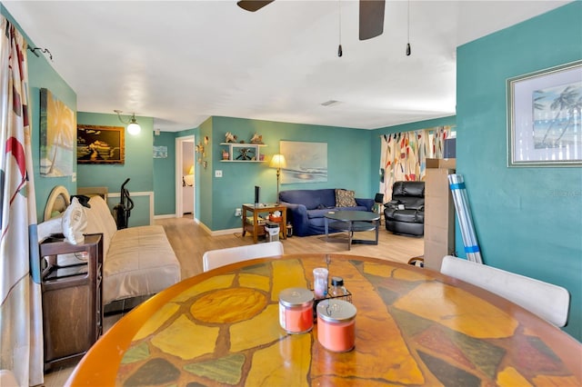 dining space with ceiling fan and light hardwood / wood-style flooring