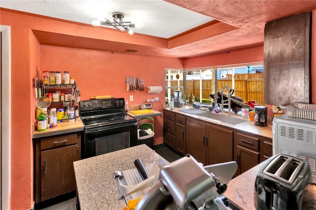 kitchen with a raised ceiling and black / electric stove