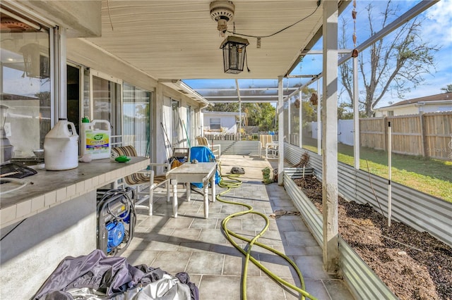 view of patio featuring glass enclosure