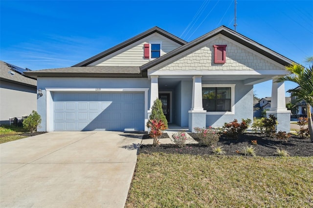 view of front of property with a porch, a garage, and a front lawn