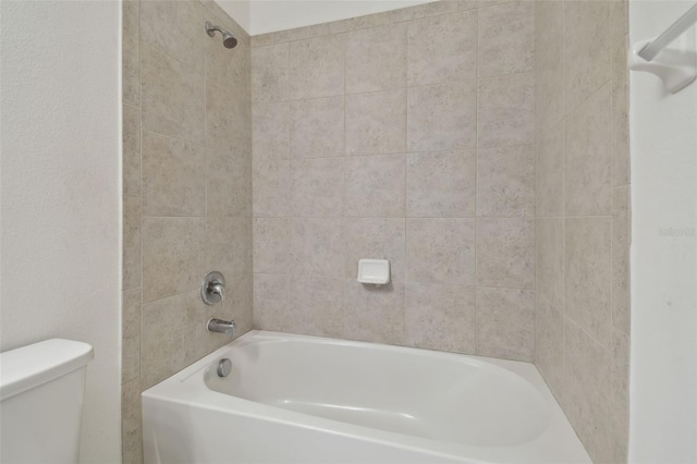 bathroom with tiled shower / bath and toilet