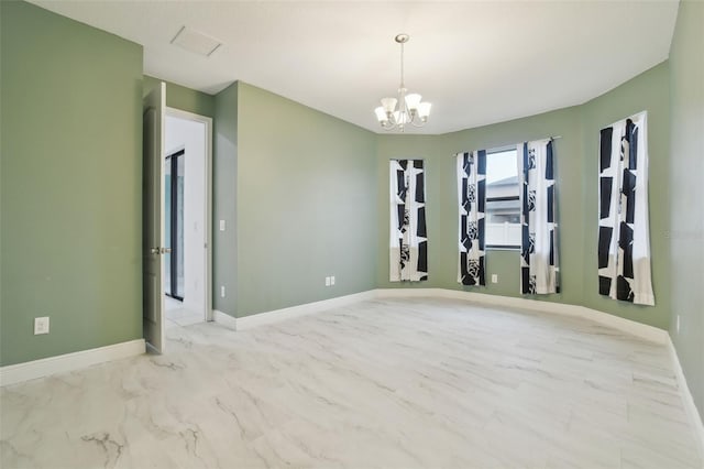 unfurnished room featuring a chandelier