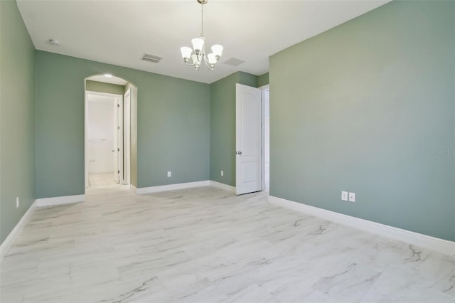 spare room featuring a notable chandelier