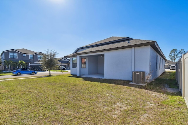 view of side of property featuring central AC unit, a yard, and a patio area