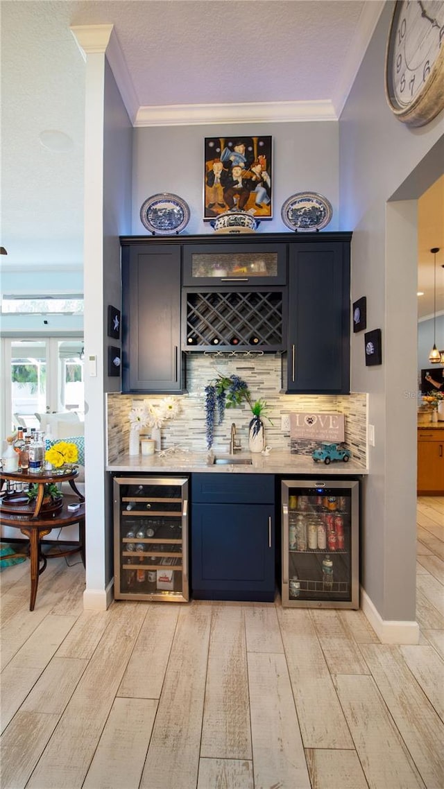 bar with crown molding, wine cooler, light wood-type flooring, and decorative backsplash