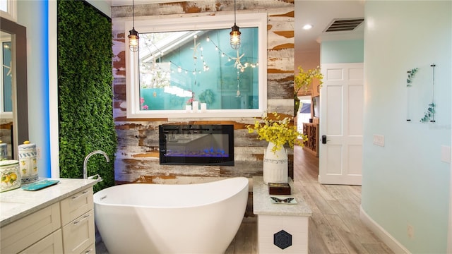 bathroom featuring hardwood / wood-style floors, vanity, and a washtub