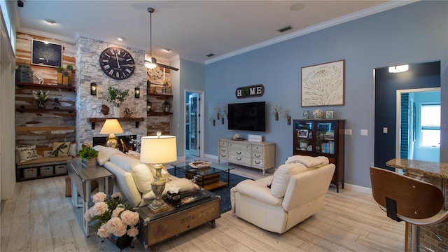 living room with crown molding, a fireplace, and light hardwood / wood-style floors