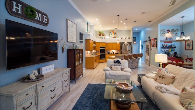 living room featuring an inviting chandelier, ornamental molding, and light wood-type flooring