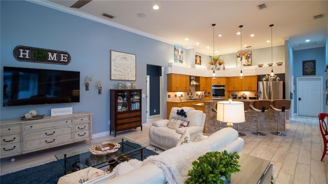 living room with crown molding, light hardwood / wood-style floors, and a high ceiling