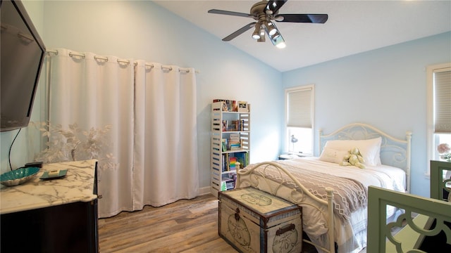 bedroom featuring ceiling fan, vaulted ceiling, and light hardwood / wood-style flooring