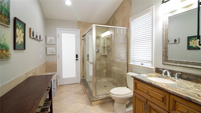 bathroom with vanity, a shower with shower door, tile patterned floors, and toilet