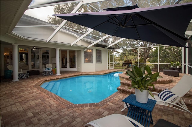 view of pool featuring french doors, ceiling fan, glass enclosure, and a patio