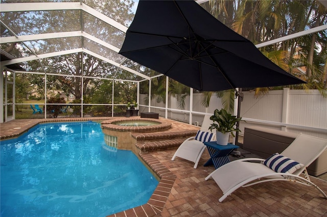 view of pool featuring a patio, glass enclosure, and an in ground hot tub