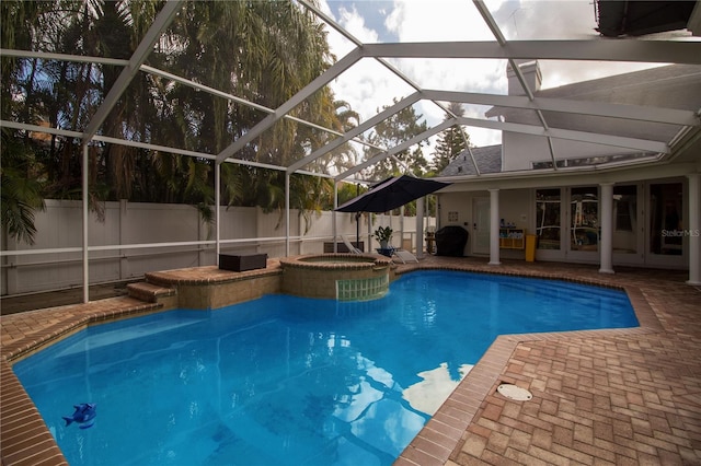 view of swimming pool with a patio, glass enclosure, and an in ground hot tub