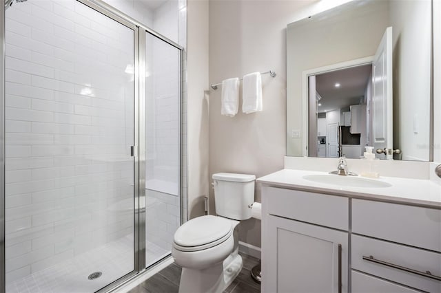 bathroom with vanity, hardwood / wood-style flooring, toilet, and walk in shower