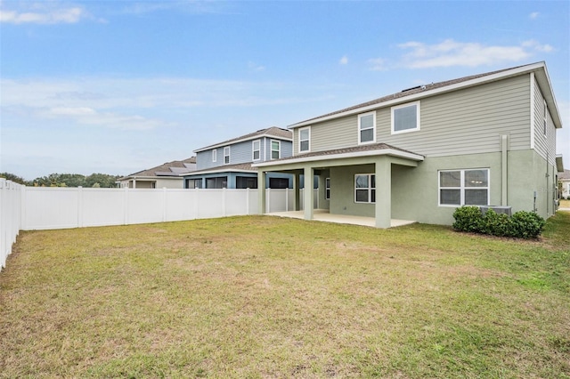 back of property with a yard and a patio area