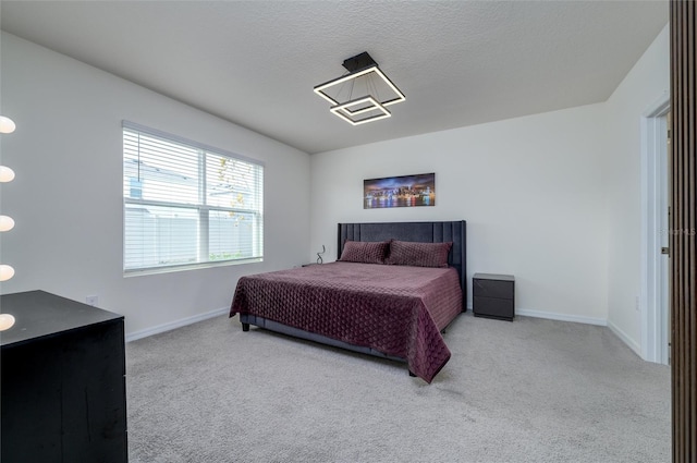 bedroom with light carpet and a textured ceiling