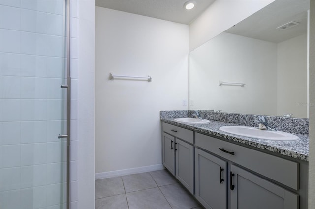 bathroom featuring vanity, a shower with shower door, and tile patterned flooring