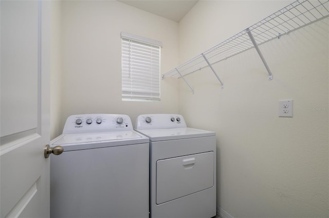 clothes washing area featuring washer and clothes dryer